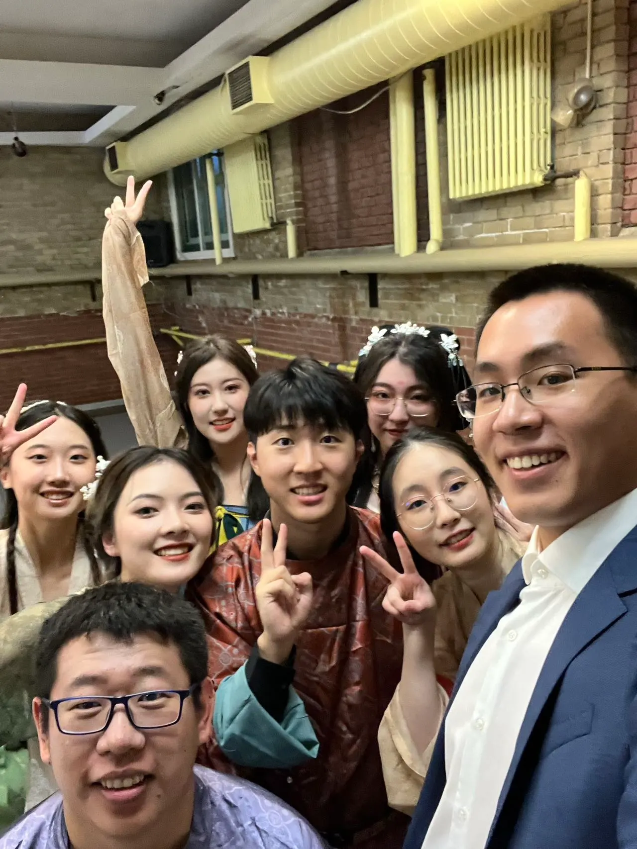 Group selfie after a performance, everyone dressed up