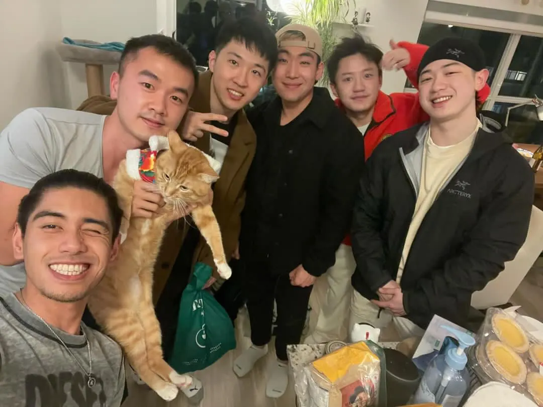 Friends posing with an orange cat