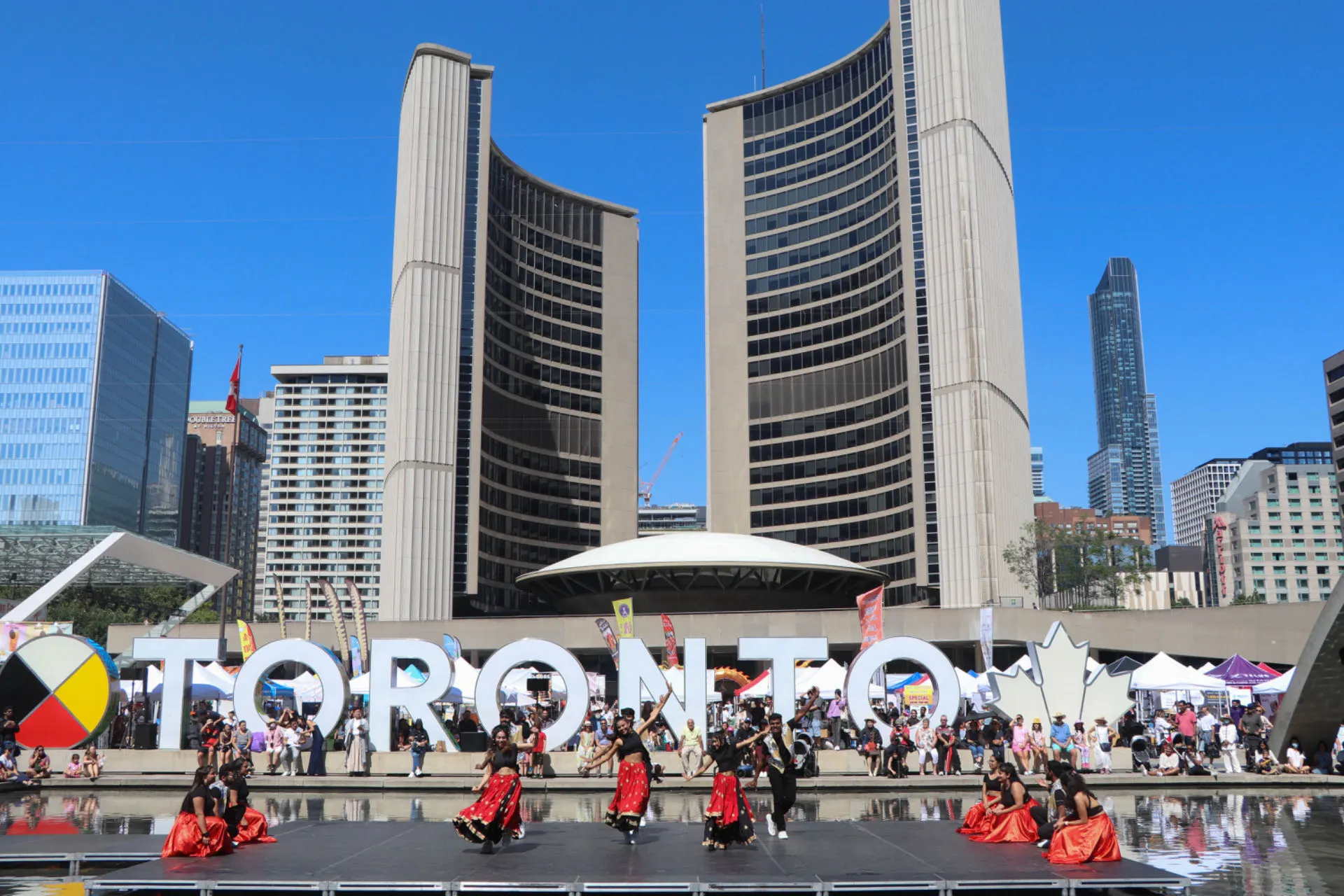Performers in front of the Toronto sign at Nathan Phillips Square